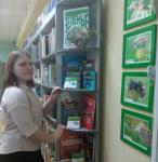 Читательница библиотеки у стенда выставки «Зелёные страницы»